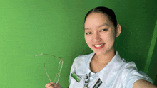 a woman holding a pair of glasses with a lanyard around her neck that says ' ui 32 '