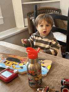 a toddler sits at a table with a book that says that