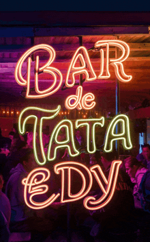 a neon sign that says bar de tata edy is lit up