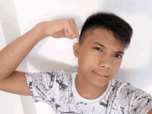 a young man flexes his muscles in front of a white background