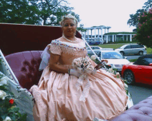 a woman in a pink dress is sitting in a horse drawn carriage holding a bouquet of flowers