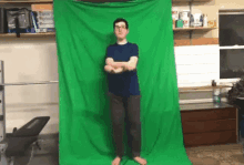 a man is standing in front of a green screen in a room .