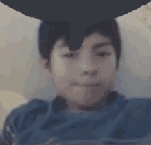 a close up of a young boy 's face with a balloon on his head .