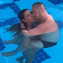 a man and a woman kissing in a swimming pool