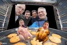 a group of men are taking a selfie with a chicken in the oven