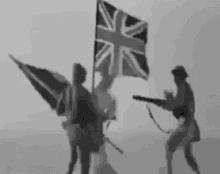 two soldiers are holding a british flag and a gun .