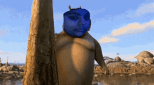 a cartoon character with a blue face and horns standing next to a tree