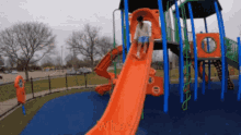 a person is going down an orange slide at a playground with the words " where " on the bottom