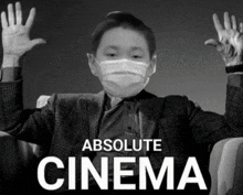 a black and white photo of a boy wearing a mask with the words absolute cinema behind him