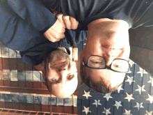 two men are upside down in front of a flag