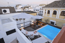 an aerial view of a swimming pool with umbrellas and lounge chairs