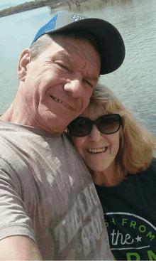 a man and a woman are posing for a picture and the woman is wearing a shirt that says " from the "