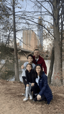 a family poses for a picture in front of a bridge