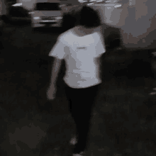 a blurry image of a person walking down a street at night .