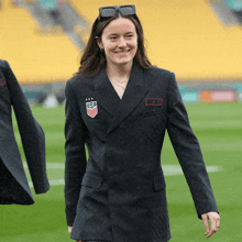 a woman wearing a black usa jacket smiles