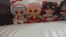 a group of stuffed dolls sitting on a bed