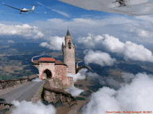 a picture of a cloud castle with a plane in the background