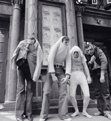 a group of people standing in front of a building with a sign that says ' sesame street '