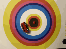 a red toy car is driving through a colorful target