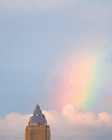 a rainbow is visible in the sky above a tall building