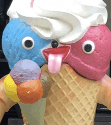 a statue of an ice cream cone with two ice cream cones on it 's head