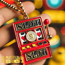 a person is holding a slot machine shaped pendant