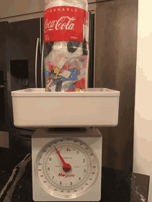 a coca cola bottle is sitting on top of a scale