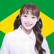 a woman in a white shirt is smiling in front of a green and yellow flag .