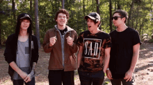 a group of young men are posing for a picture and one of them has a shirt that says sad