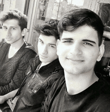 three young men are posing for a picture in front of a sign that says ' a '