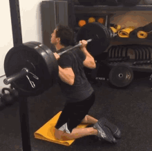 a man squatting with a barbell that says rogue