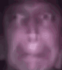 a blurry picture of a man 's face with a purple background