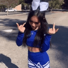 a cheerleader with a bow in her hair is giving the middle finger