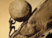 a statue of a man pushing a large rock up a hill .