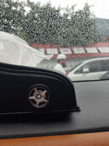 a tissue box with a wheel on it sits on a car dashboard