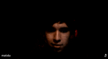 a man 's face is shown in a dark room with the words matidu below it