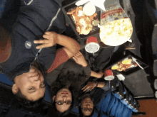 a group of people sitting at a table with a bag of cinema popcorn