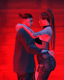 a man and a woman hugging each other in a red light