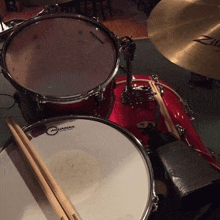 a red drum set with a drum head that says aquarian on it