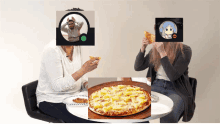 three people sitting at a table eating pizza with their faces obscured