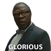 a man in a suit and bow tie has the word glorious on his chest