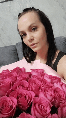 a woman holding a bouquet of pink roses