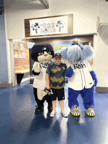 a boy poses with rays mascots in front of a tree house sign