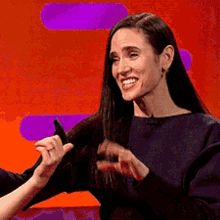 a woman with long hair is smiling while another woman holds her hair .