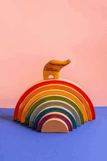 a wooden rainbow with an elephant on top