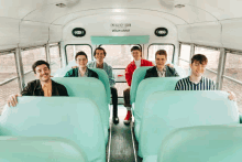 a group of young men are sitting on a bus with an emergency door