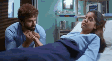 a man and a woman are holding hands in a hospital room .