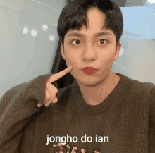 a young man wearing a sweater with the name jongho do ian written on it