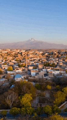 an aerial view of a town with a mountain in the background