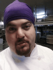 a man wearing a purple beanie and a white shirt